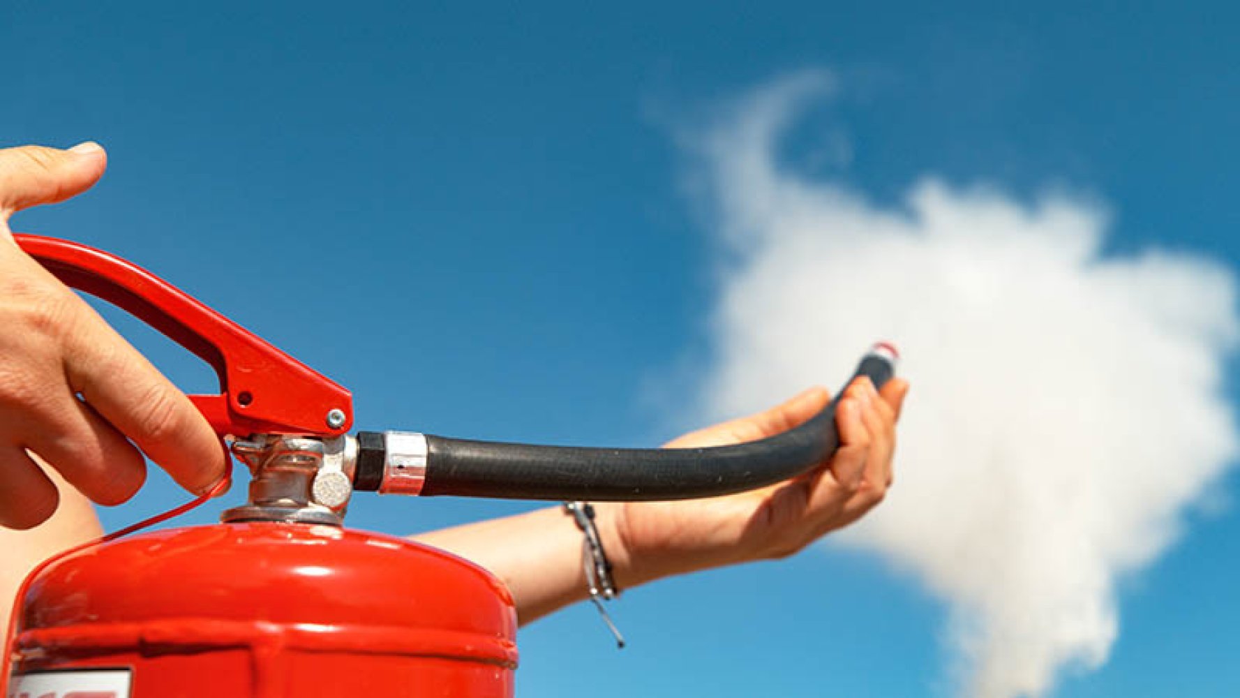 Et brannslukningsapparat spyler pulver ut i lufta.