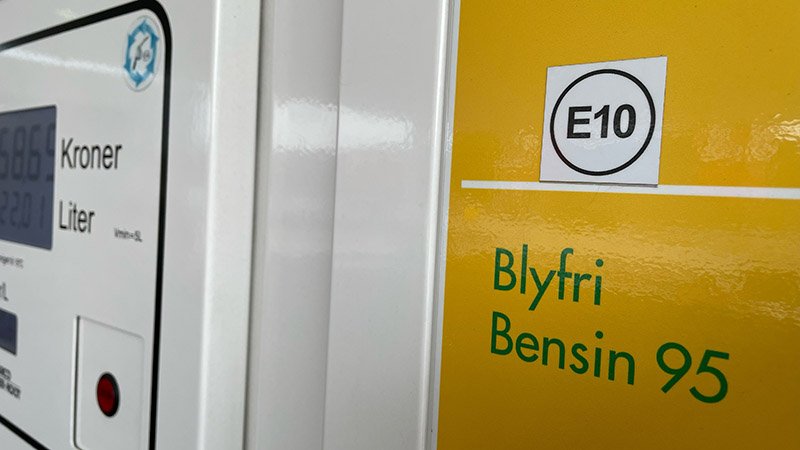 Nærbilde av bensinpumpe med gul etikett som viser E10.