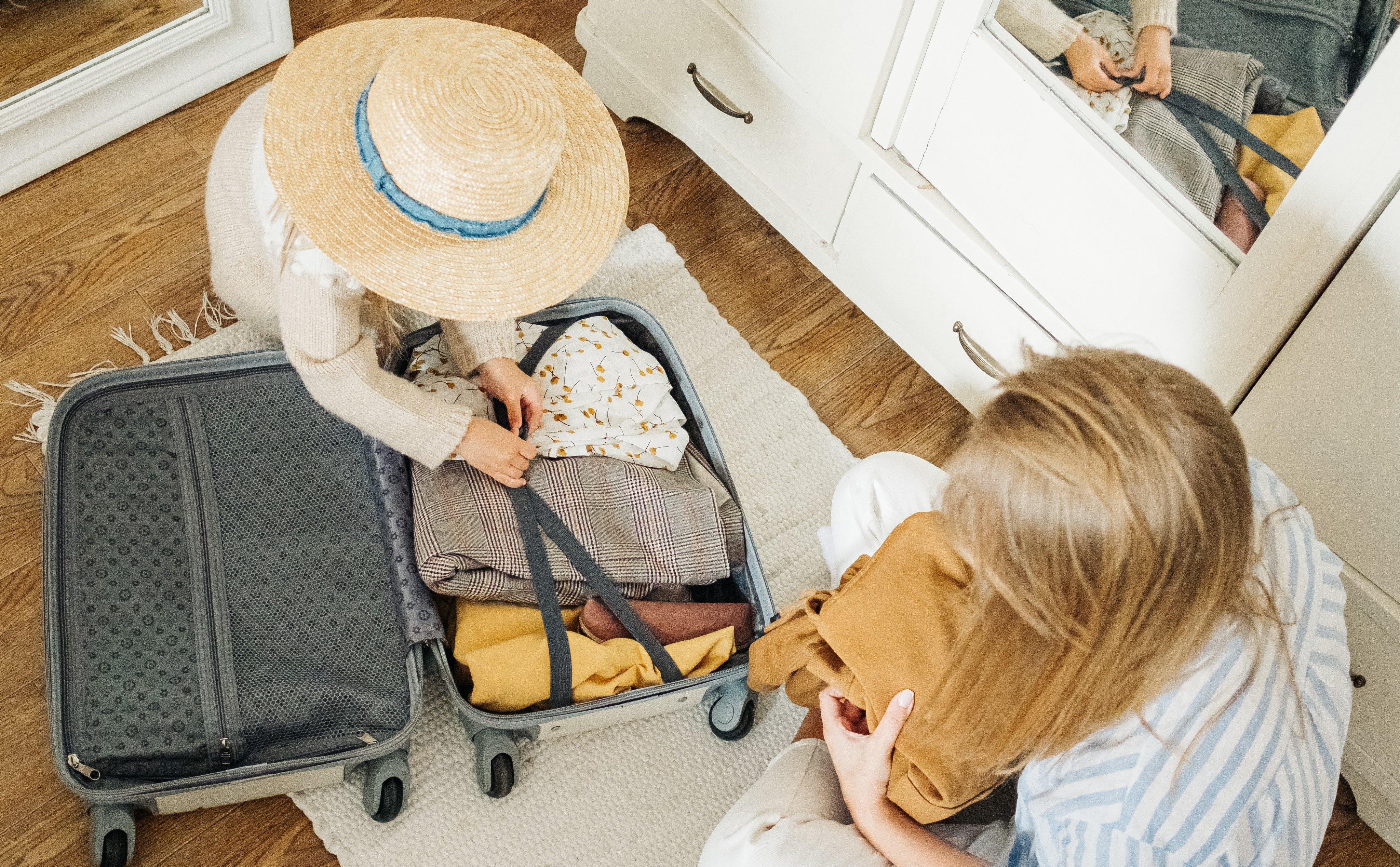 Mor og datter pakker en koffert med klær