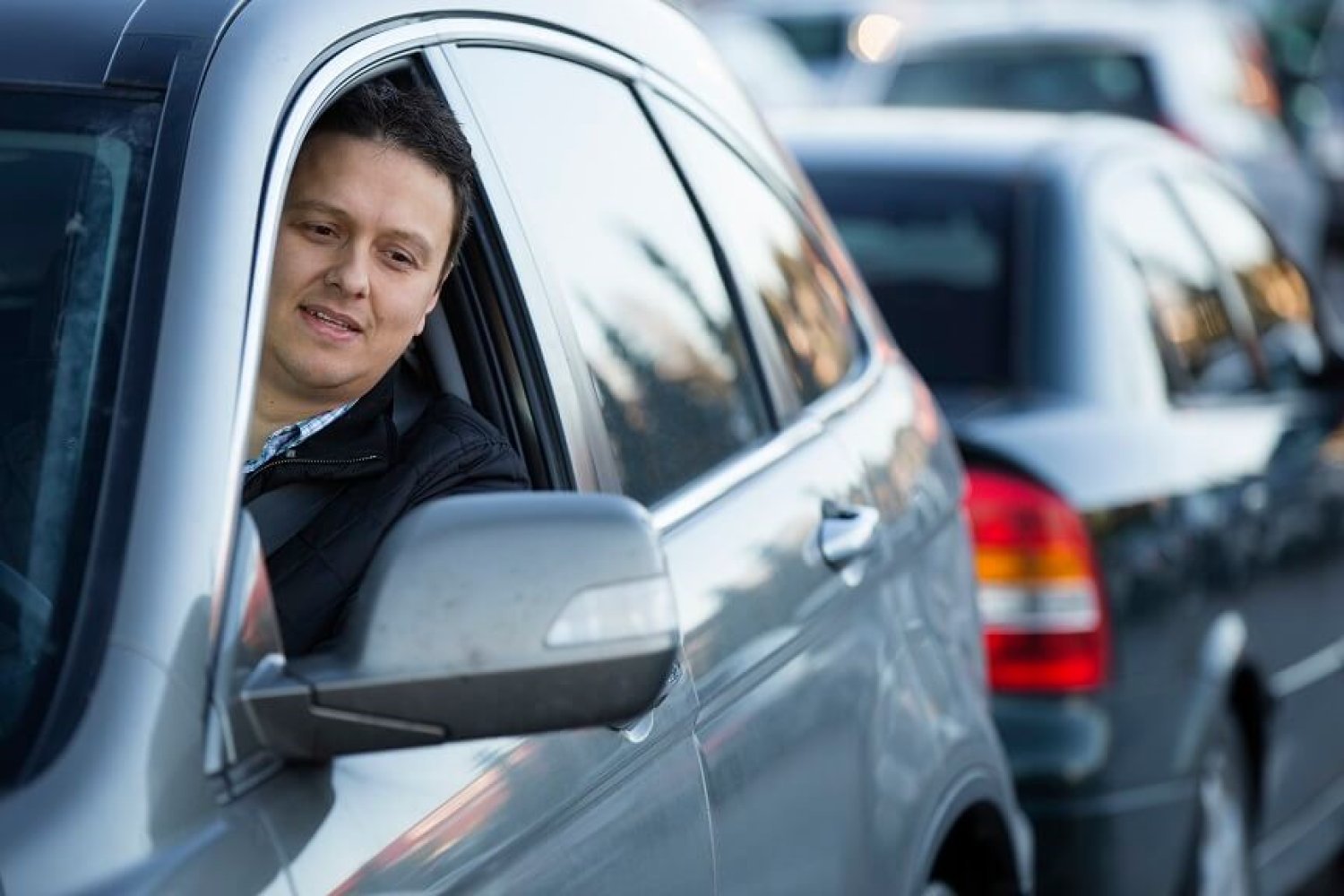 Jan Fleinsjø sitter i førersetet på en bil og ser ut vinduet i speilet for å rygge