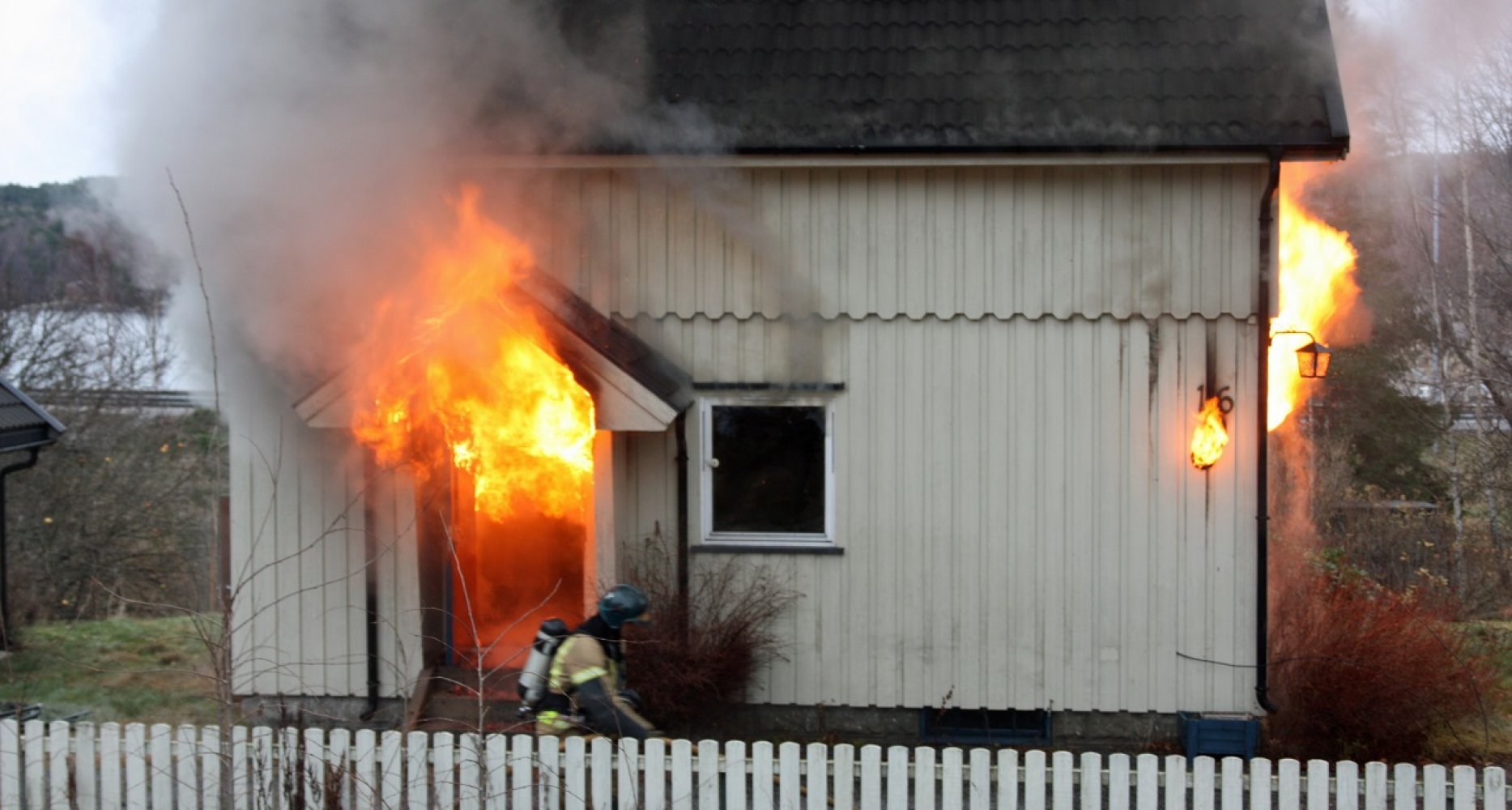 Flammer står ut av døren på en enebolig
