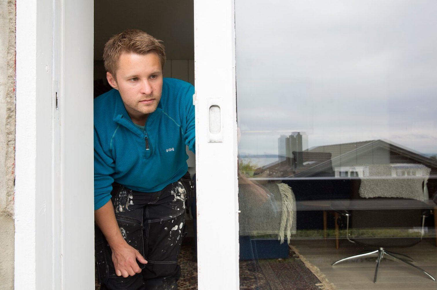 En mann inspiserer en verandadør for å se om den har en lås av god kvalitet.