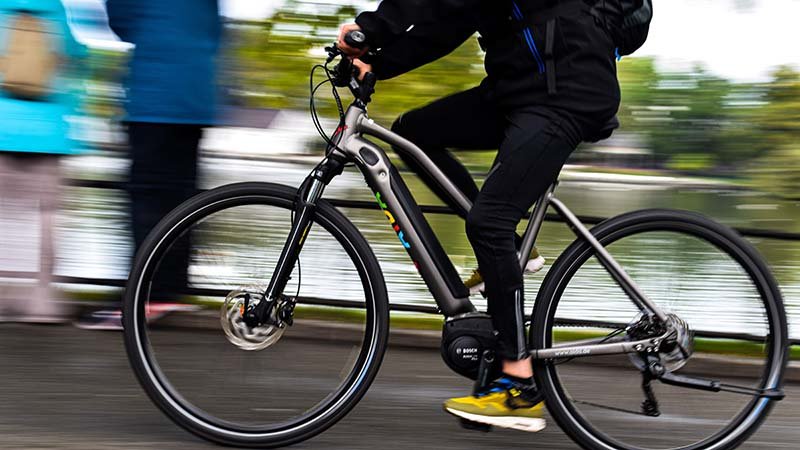 En syklist sykler langs en vei.