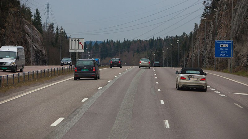 Motorvei med fire felt og flere biler.