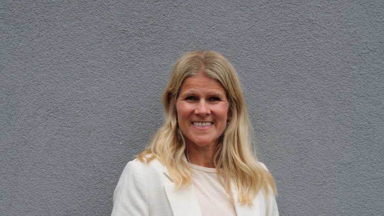 Mona Eek-Jensen i hvit t-skjorte og hvit jakke