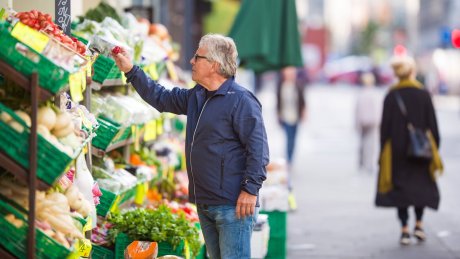 En man kikker på grønnsaker utenfor en grønnsakshandler.