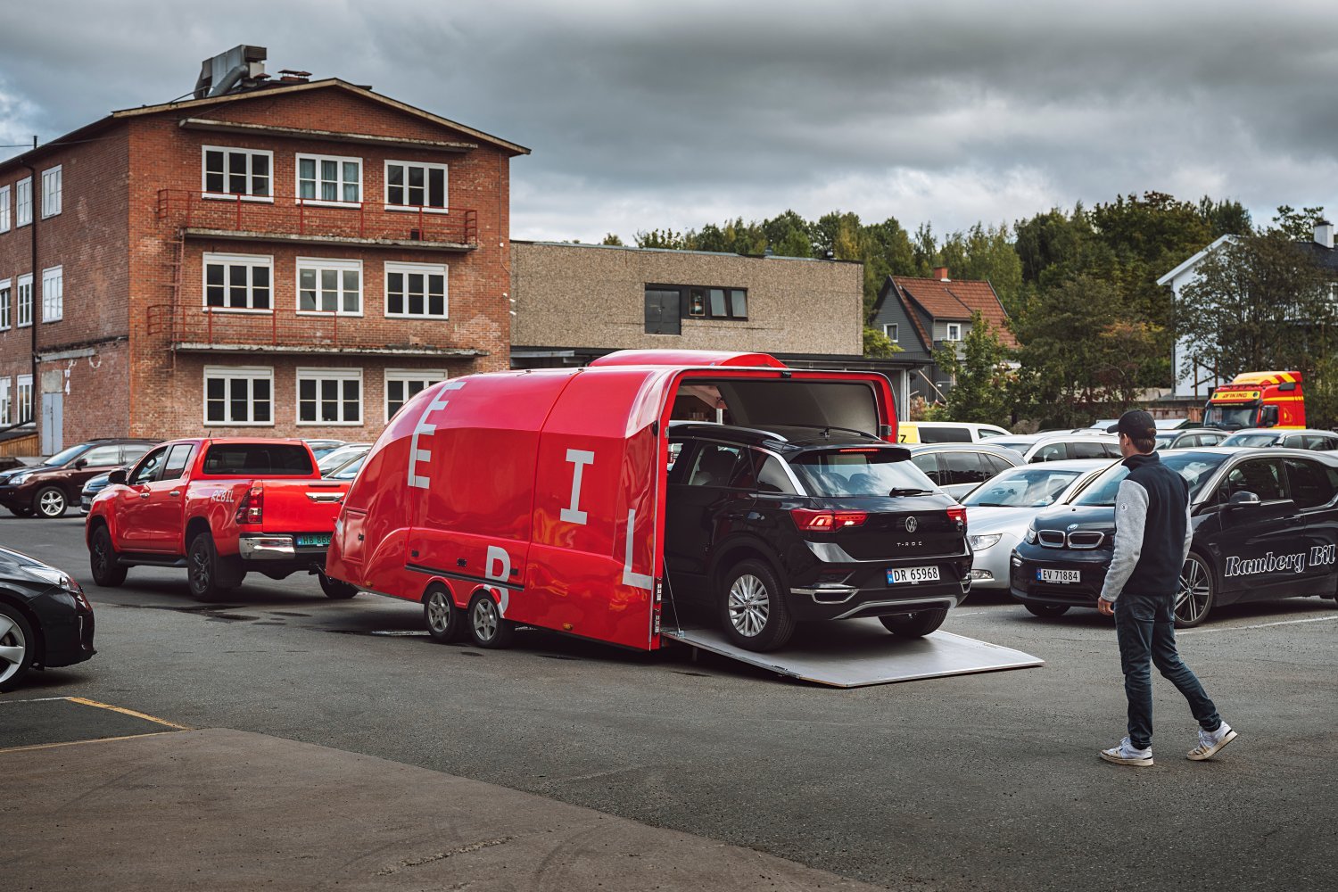 Det kjøres en personbil inn på en rød Rebil-henger.