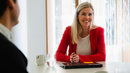 Dame smiler i lønnsforhandlingsmøte