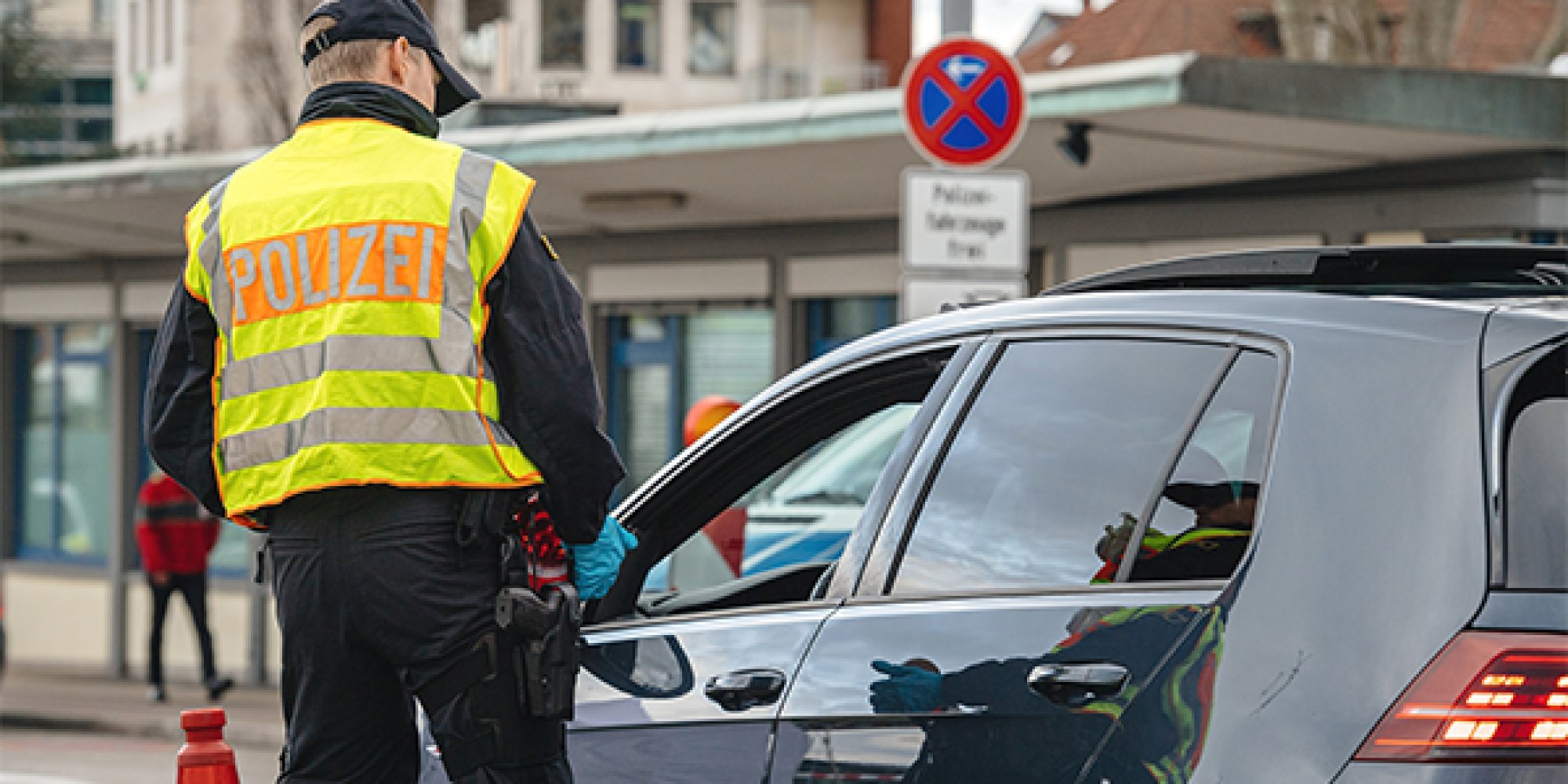 En tysk politiman snakker med en sivil bilist.