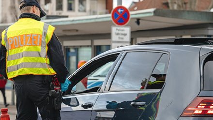 En tysk politiman snakker med en sivil bilist.