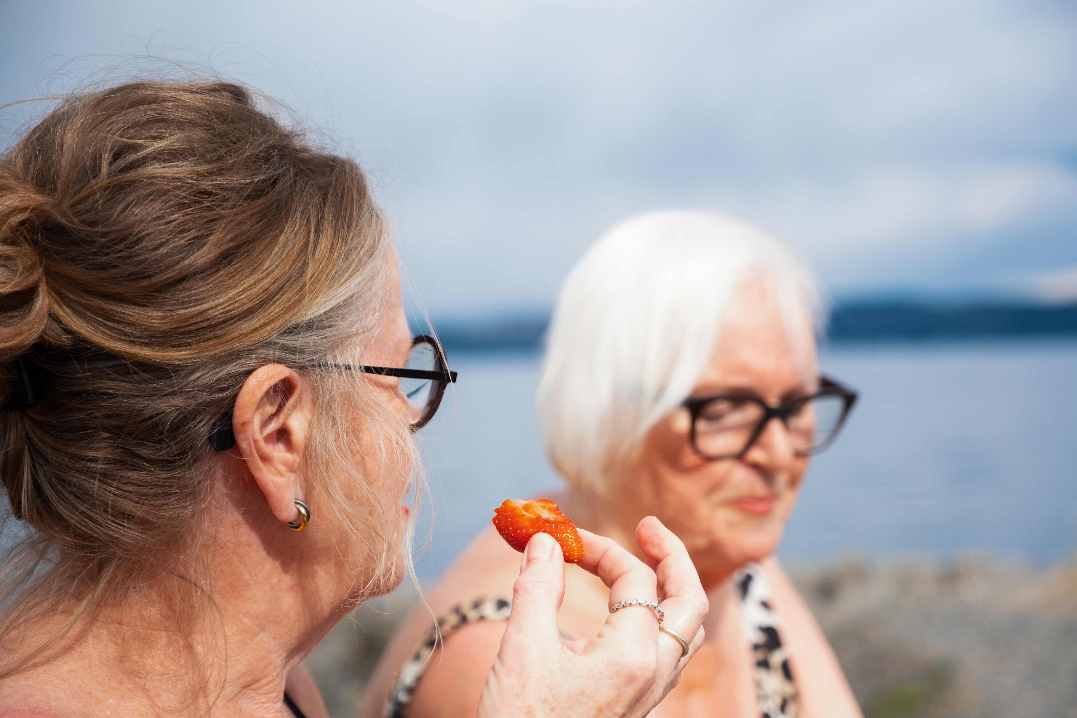 To eldre kvinner koser seg på en badestrand.