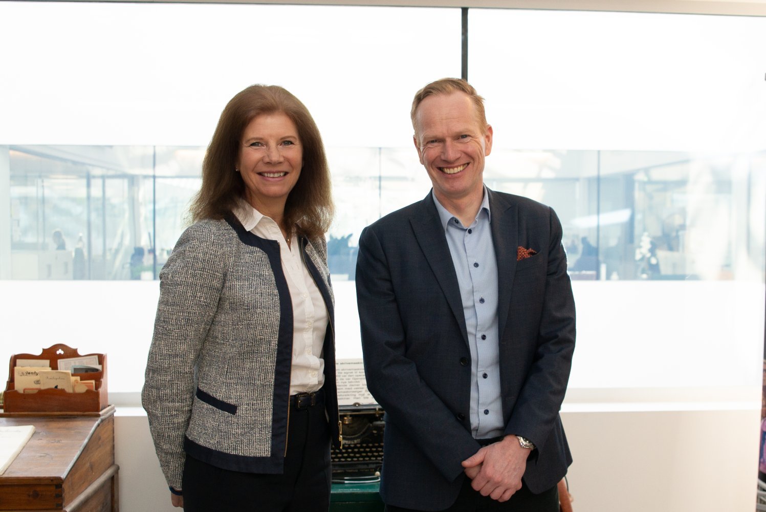 Administrerende direktør i Gjensidigestiftelsen Ingrid Lorange og Gjensidiges konsernsjef Geir Holmgren står ved siden av hverandre og smiler.