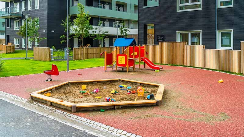 En lekeplass med sandkasse og sklie, men ingen mennesker.