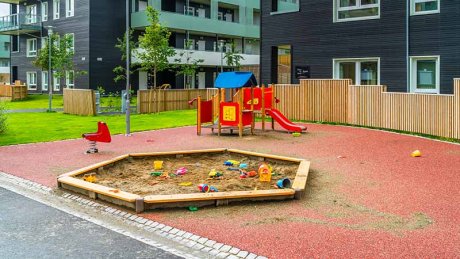 En lekeplass med sandkasse og sklie, men ingen mennesker.