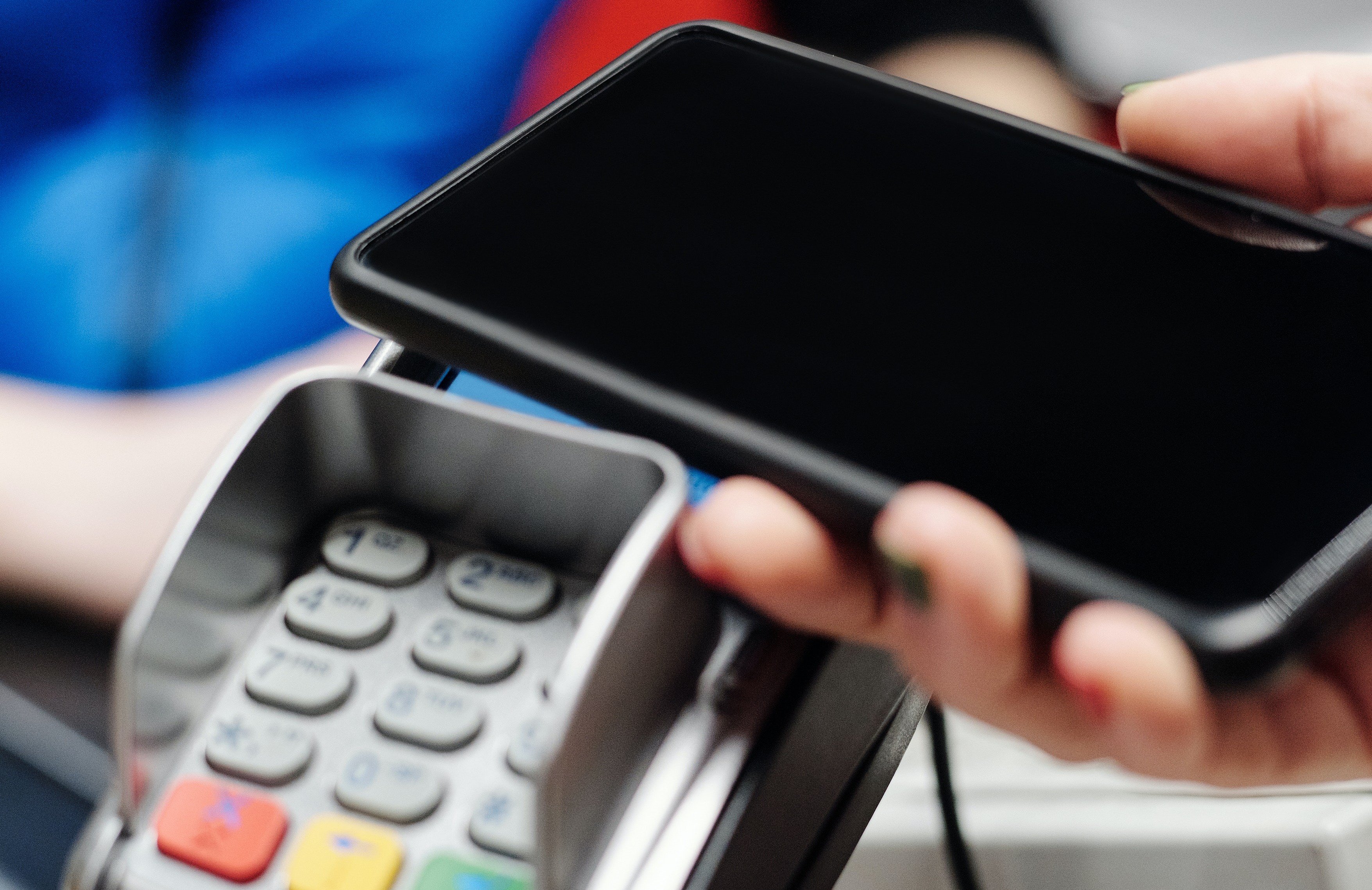 En mobil blir lagt på bankterminalen for å betale.