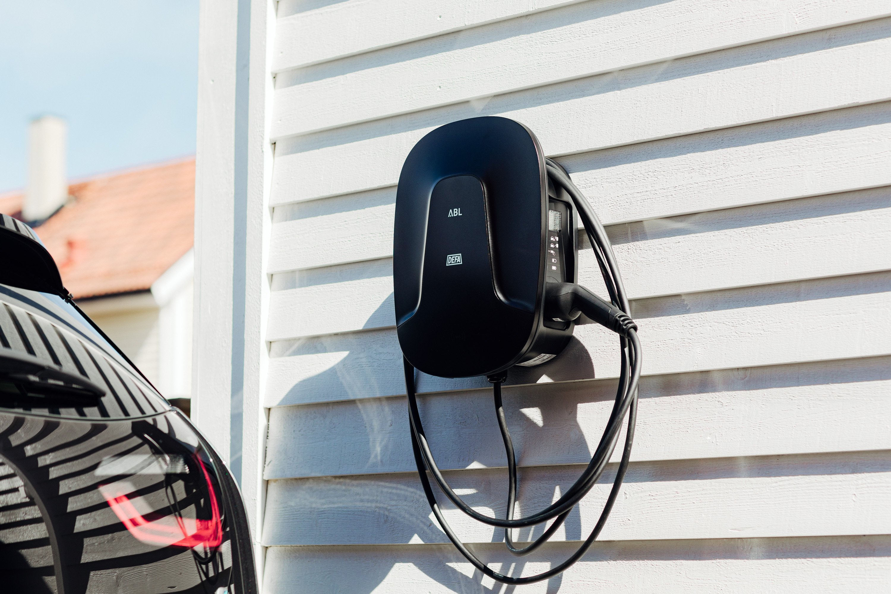 Sort elbillader montert på en yttervegg.