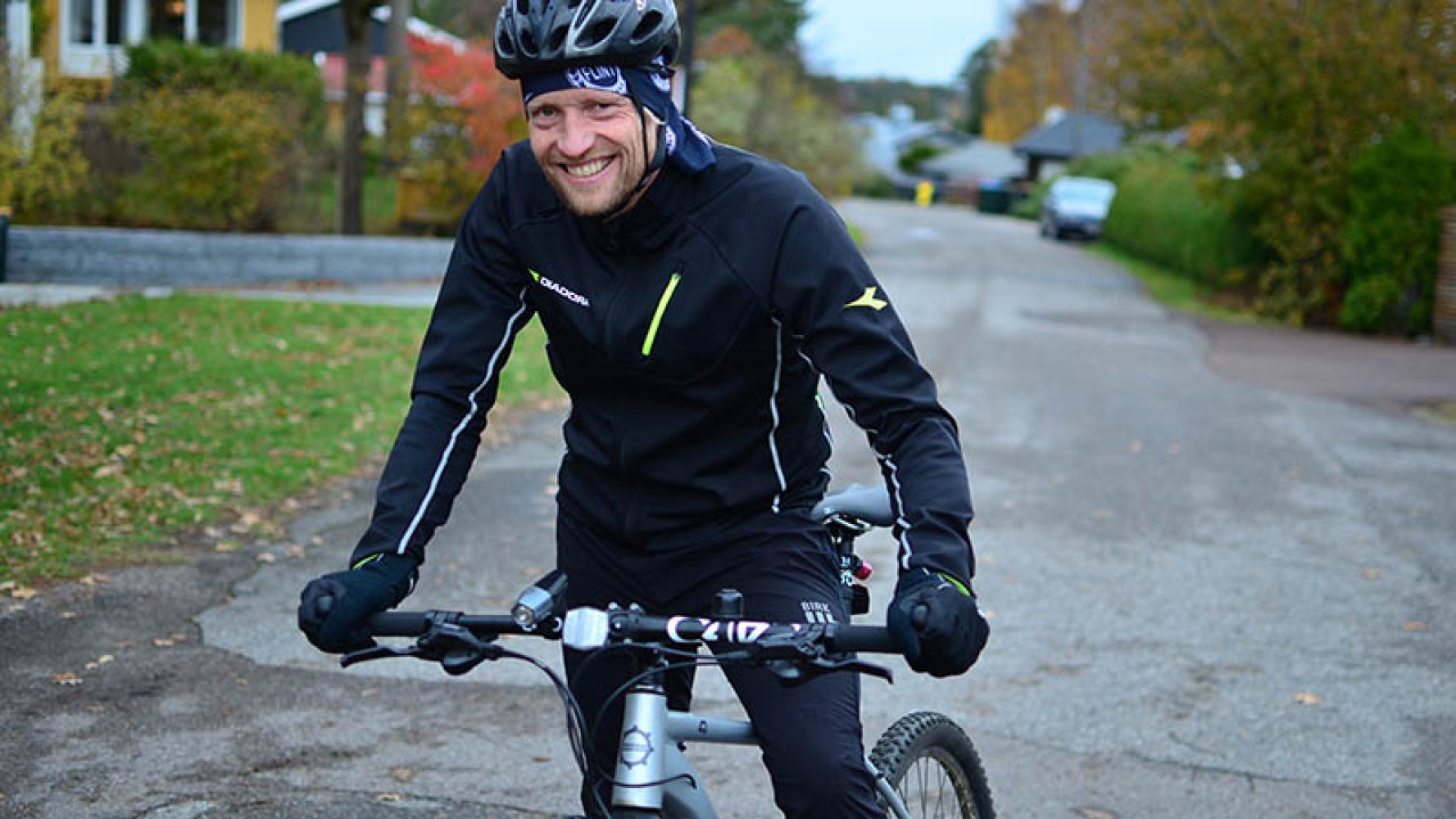 Petter Hveem på sykkel i et villastrøk.