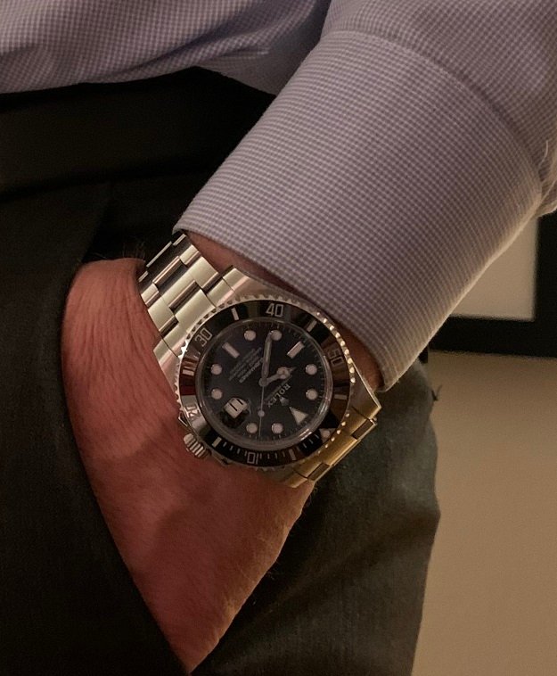 En mann med hånden i bukselommen. Han har en rolexklokke på armen.