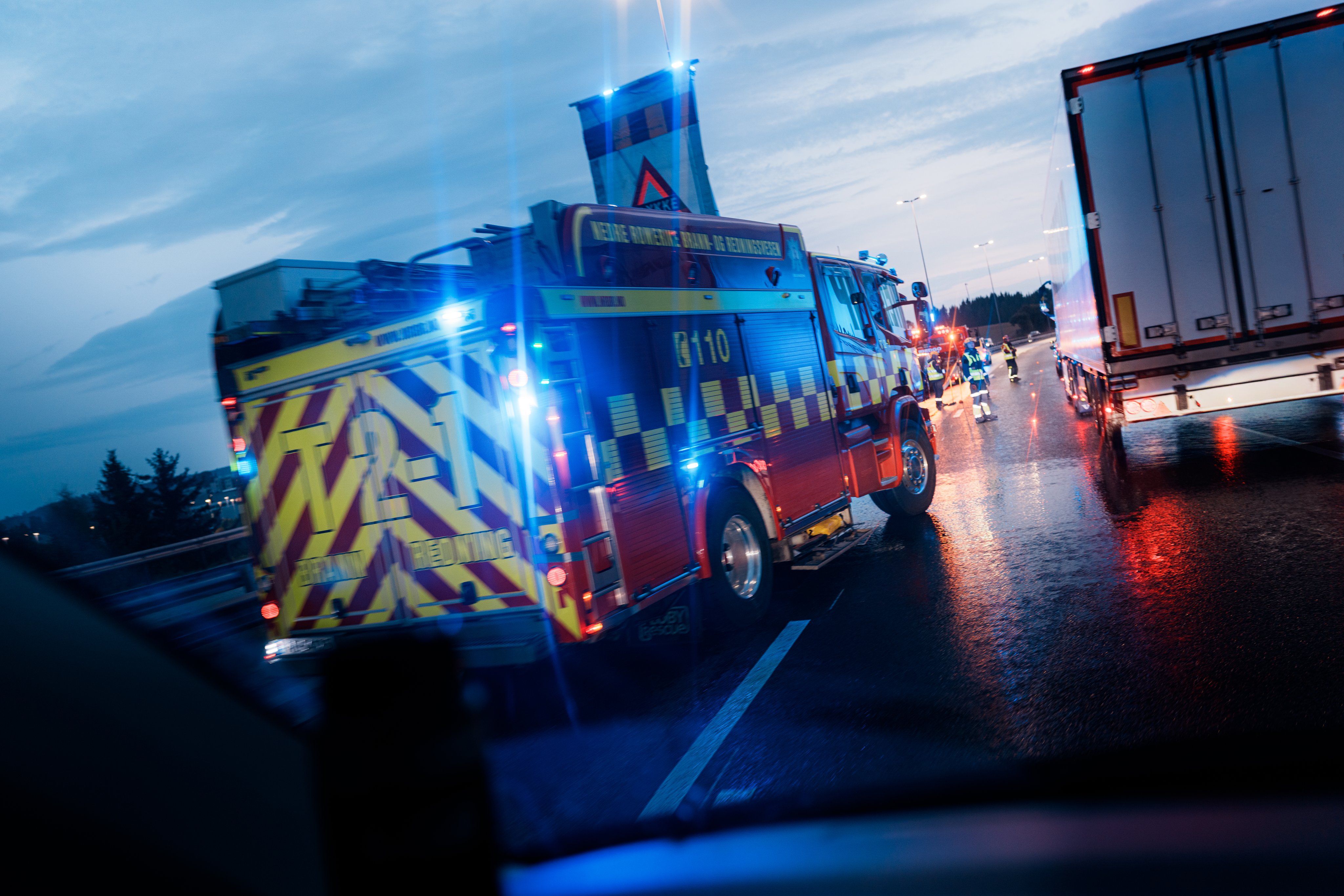 Brannbil med blålys i skumring.