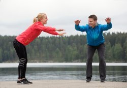 Dame står på to ben og lener seg forsiktig fremover med armene utstrakt.
