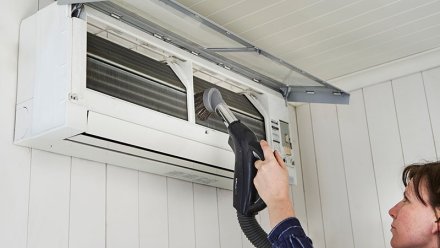 Kvinne støvsuger varmepumpe