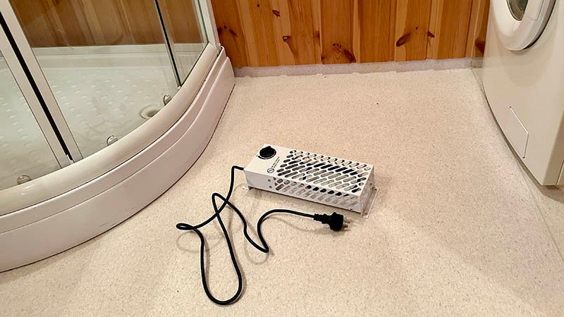 Frostvakt liggende på et baderomsgulv, ikke plugget inn i strømuttak.