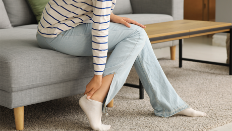 En dame holder seg på akillesen,