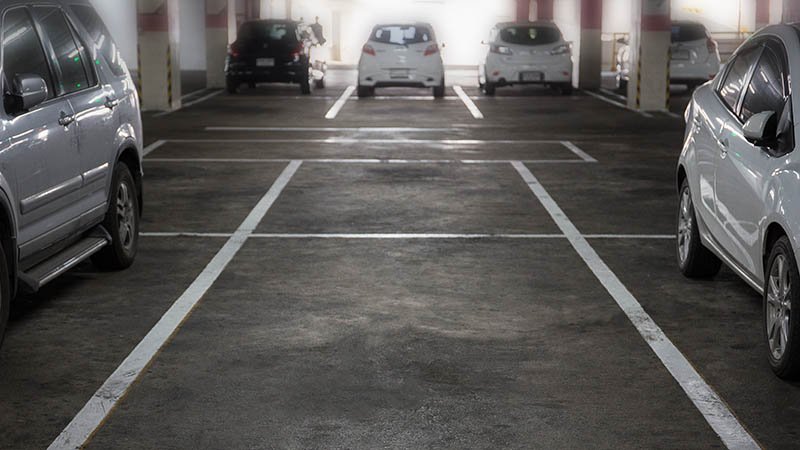 Flere biler står parkert inne i et parkeringshus.