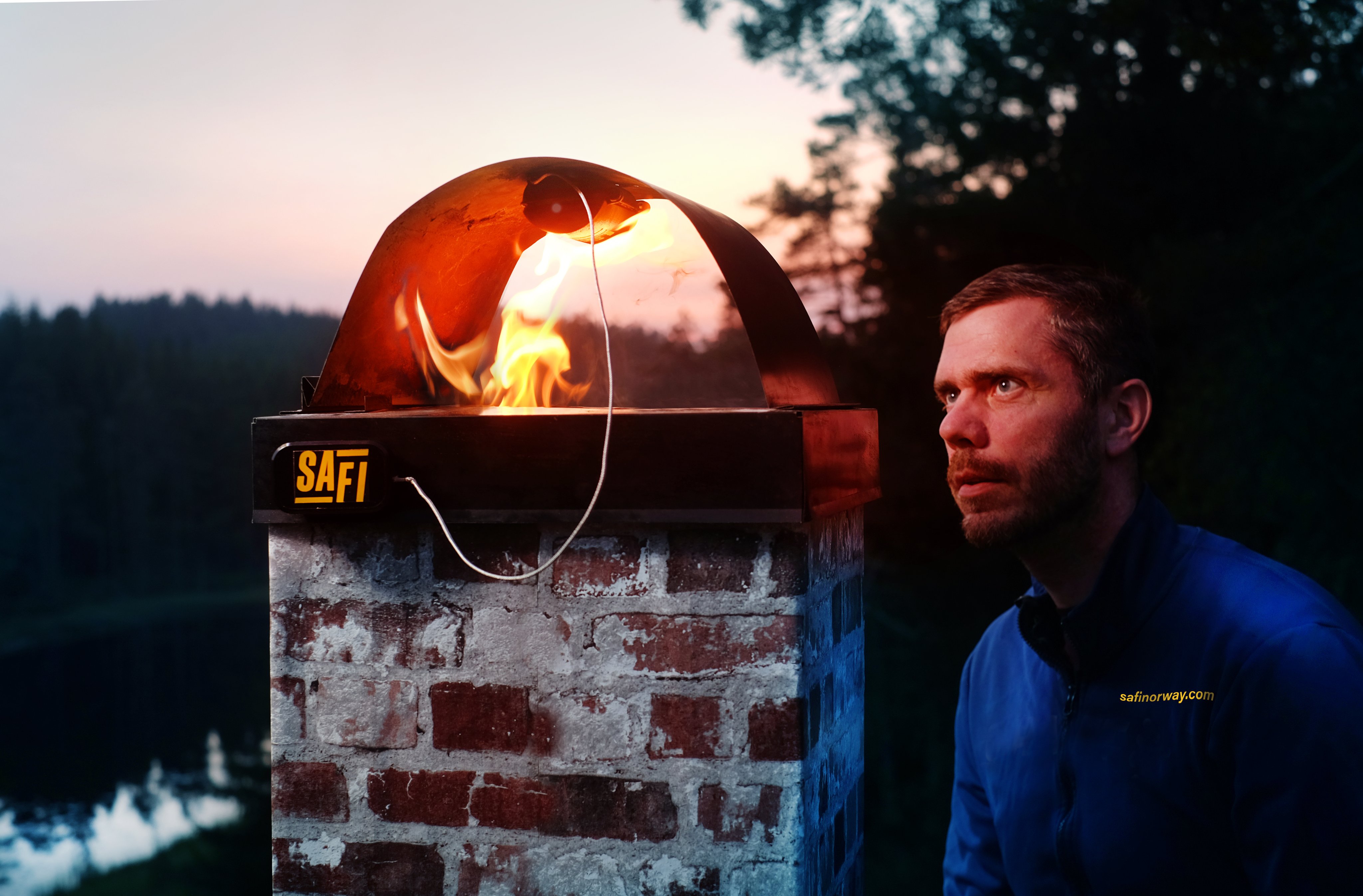 Ingolf Stokkeland står ved siden av en brennende pipe.