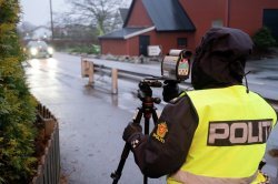 Politiet står langs veikanten med lasermåler.