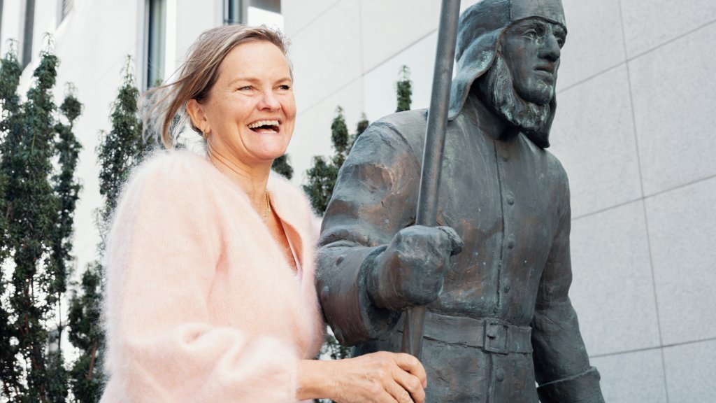 En dame i rosa cardigan står inntil Gjensidige-vekteren
