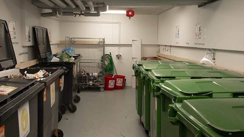 Et avfallsrom med mange søppelbeholdere.