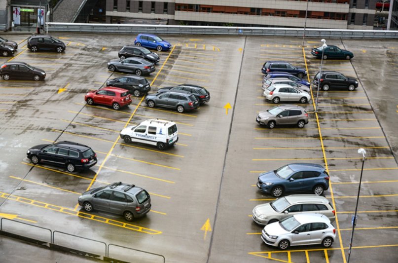 Utendørs parkeringsplass sett ovenfra, med et knuppe parkerte biler