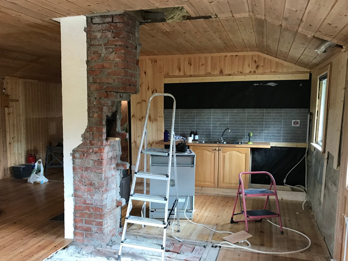 En gammel peis blir revet i en hytte