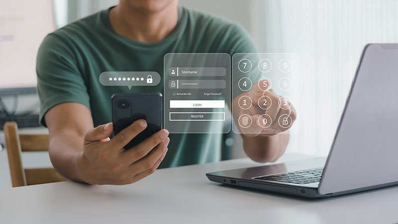 Person logger inn med mobil og datamaskin ved hjelp av tofaktorautentisering