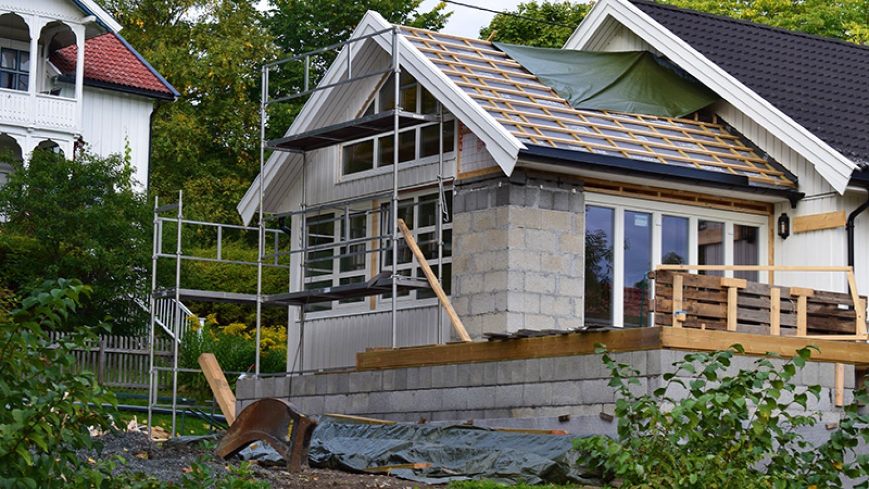 Bilde utendørs av et hus under oppbygning.