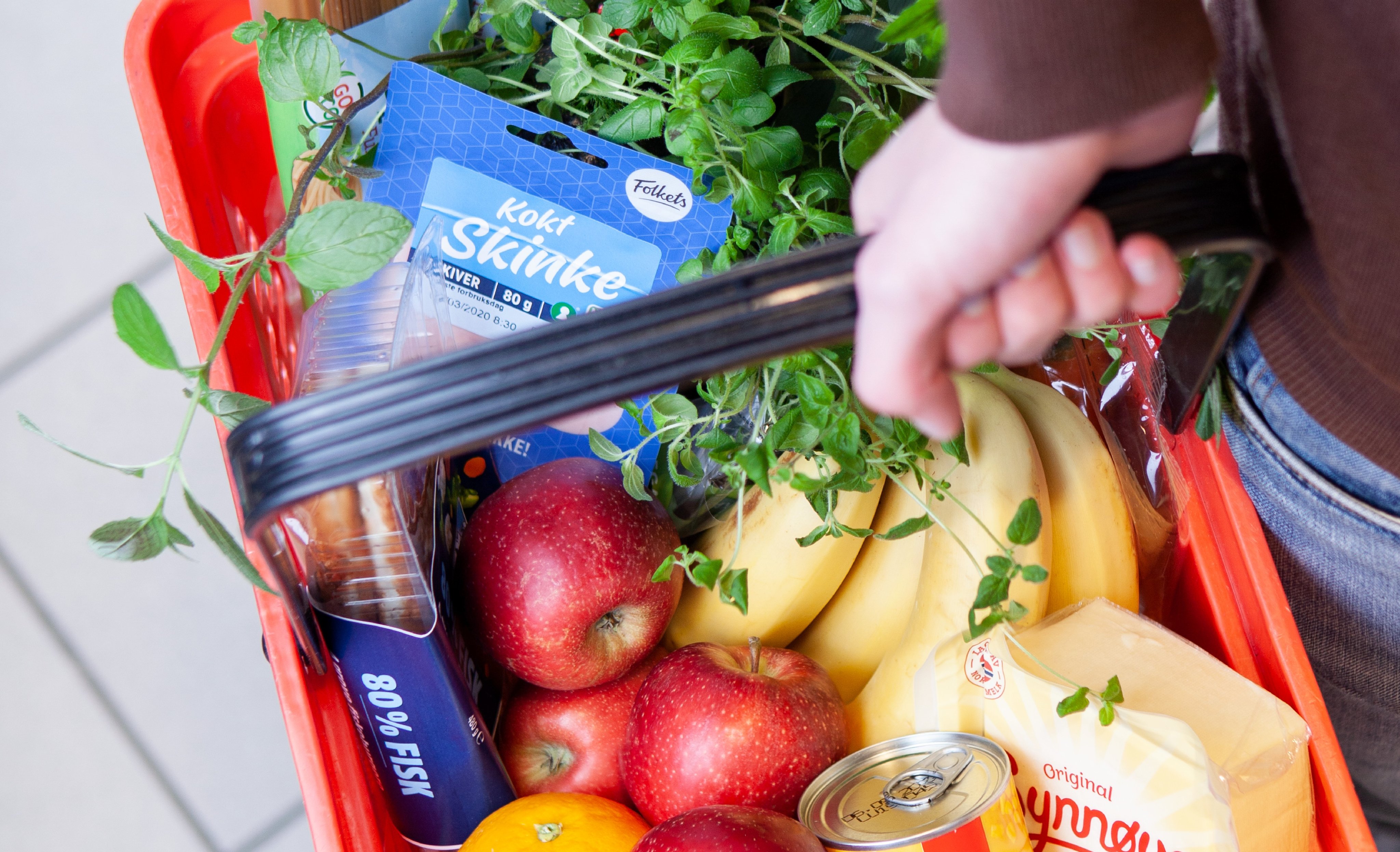 Nærbilde av en handlekurv fylt med ulike matvarer.