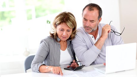 Et voksent par diskuterer teksten på et papir.