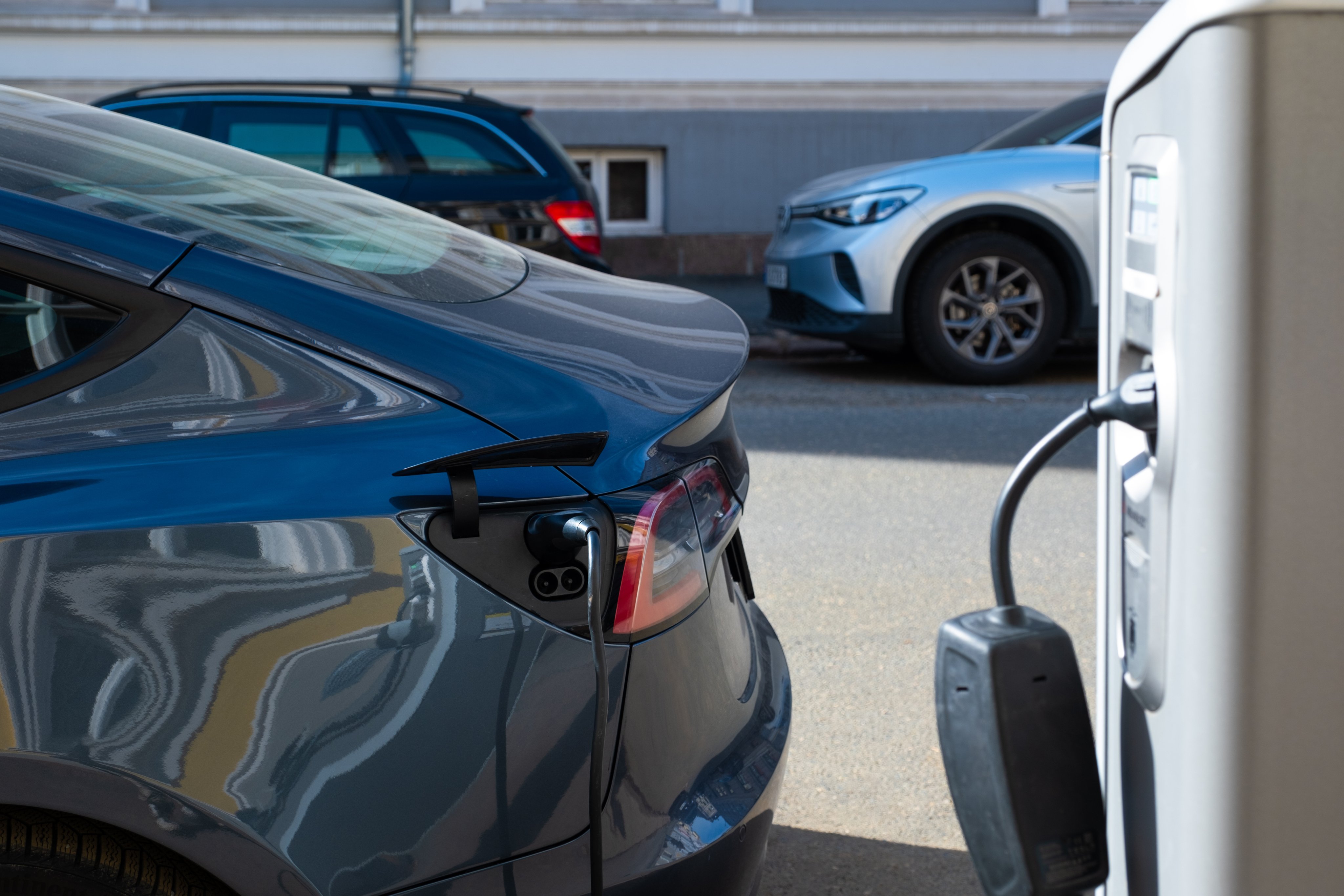 Elbil koblet til ladestasjon på gateparkering.