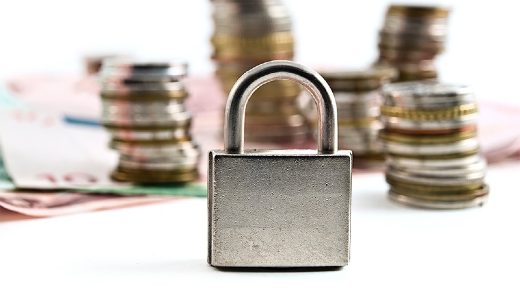 Hengelås foran stabler med mynter og sedler.