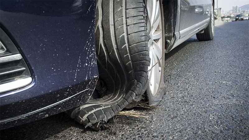 Bildekk som har revnet på en bil som står stille