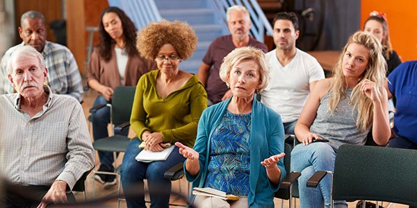10 mennesker sitter på stoler.