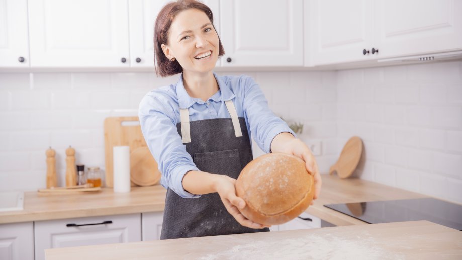 En dame holder et nybakt brød.