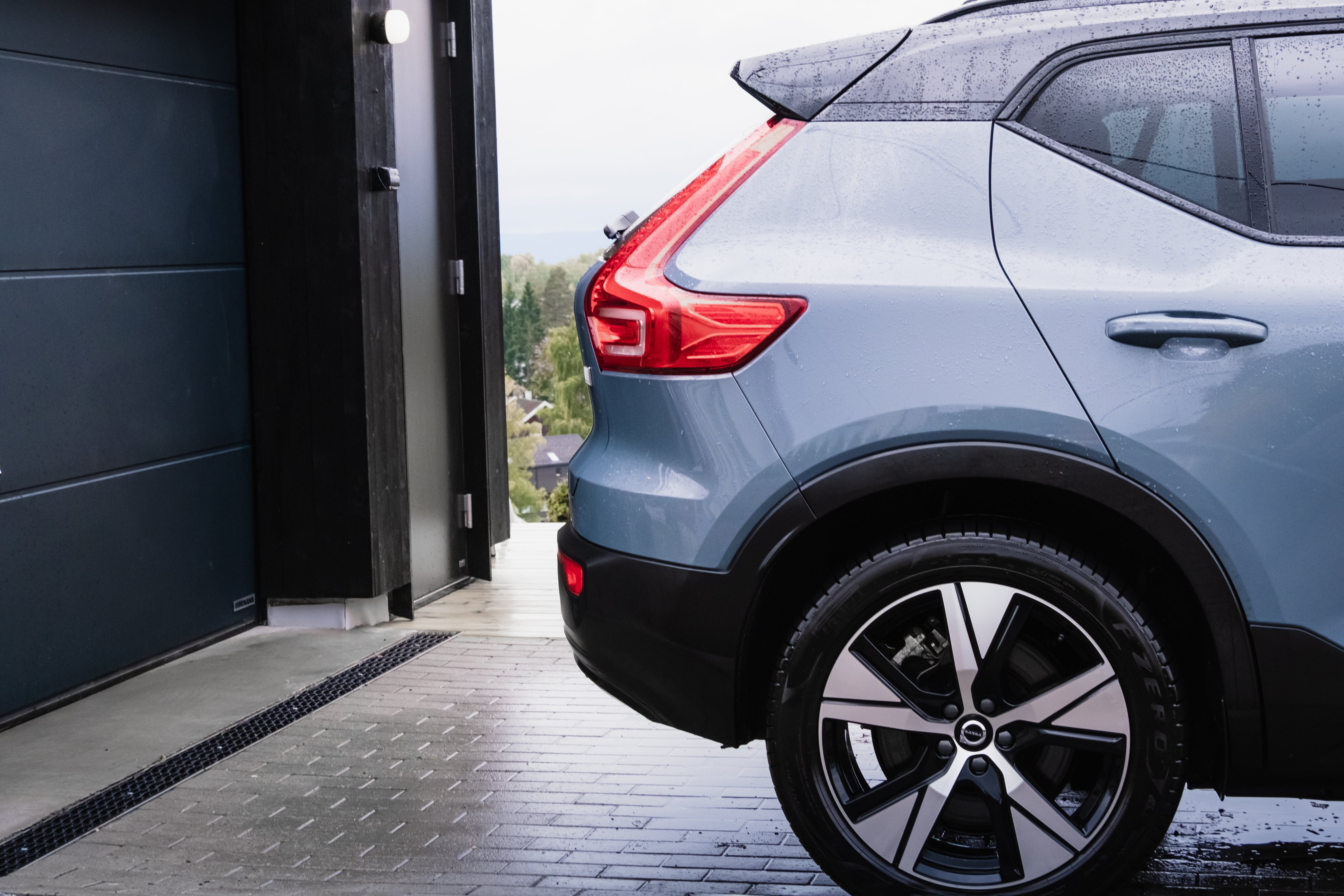 En bil står parkert foran en garasje.