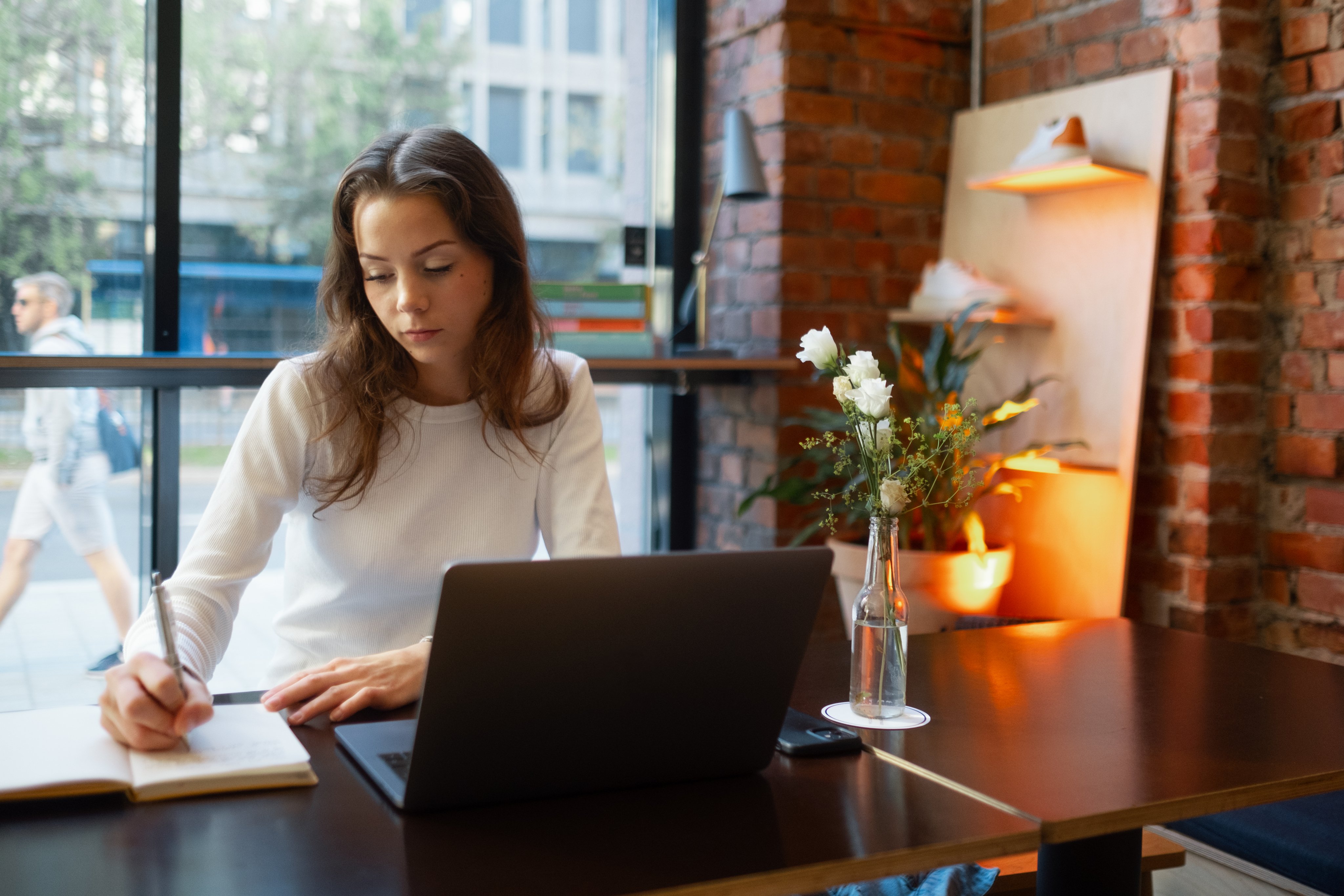 En ung kvinne sitter i en lesesal og studerer.