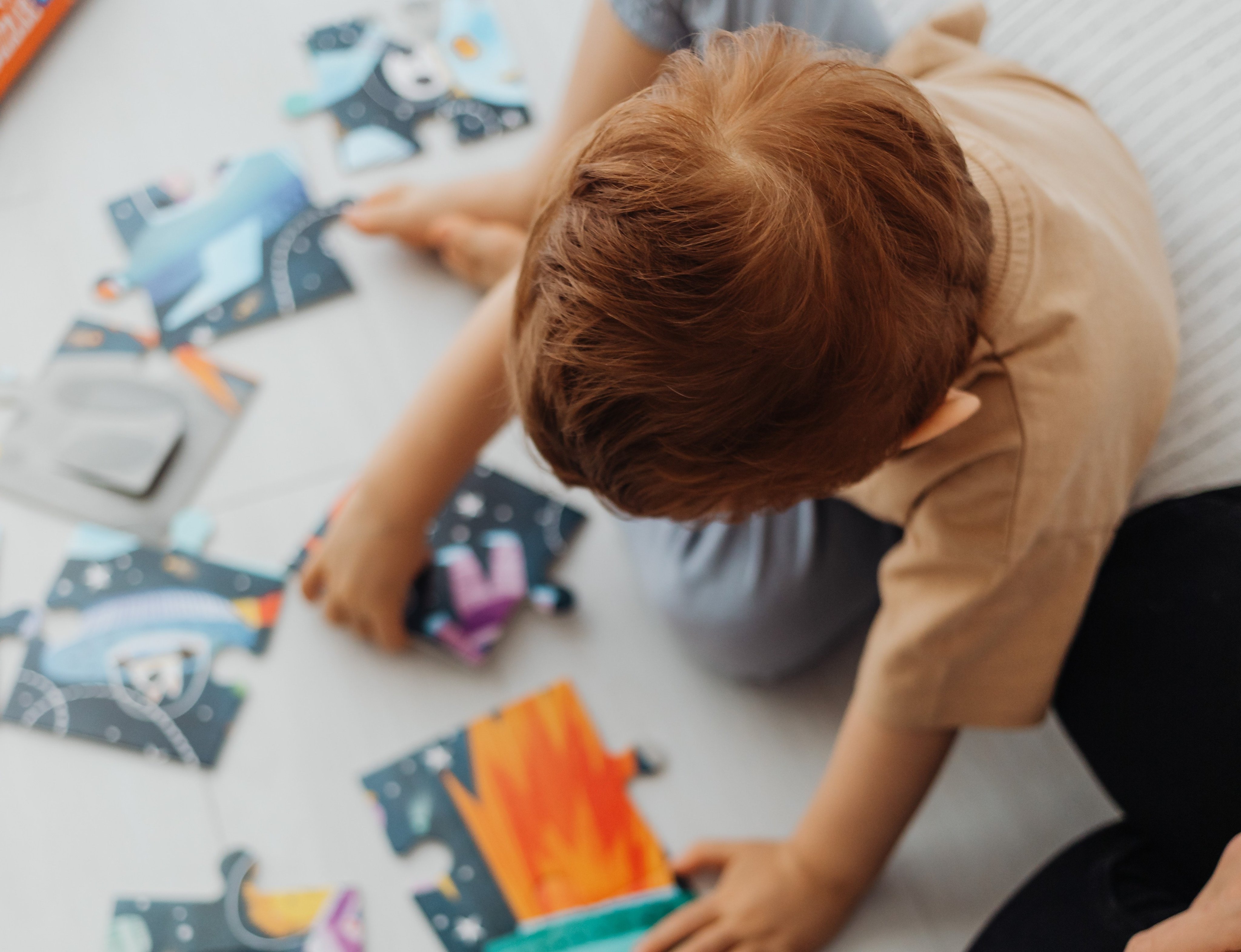 Barn sett ovenfra som leker med store puslespillbrikker