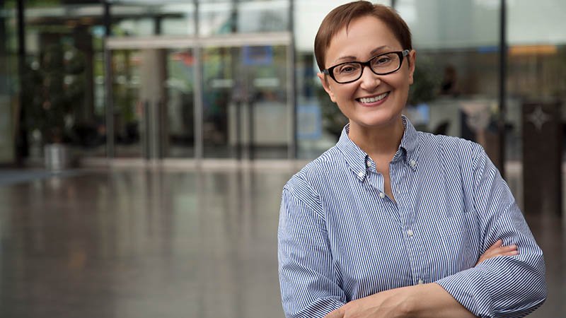 En dame smiler og ser i kamera.