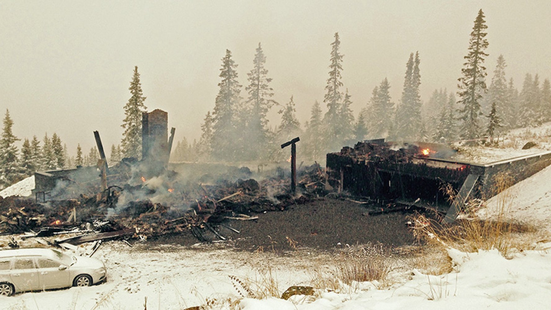 Ei hytte har brent ned til grunnen og det ryker fortsatt fra restene.