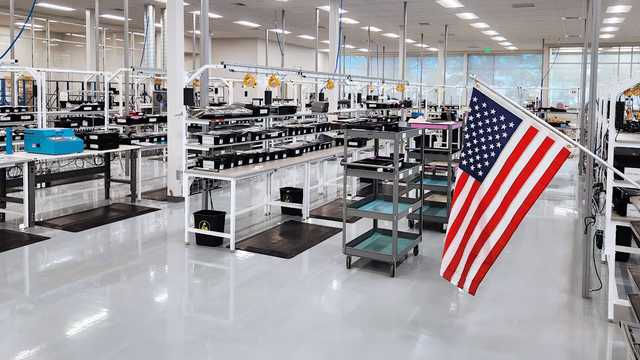 USA flag and production facility floor in Reno, NV