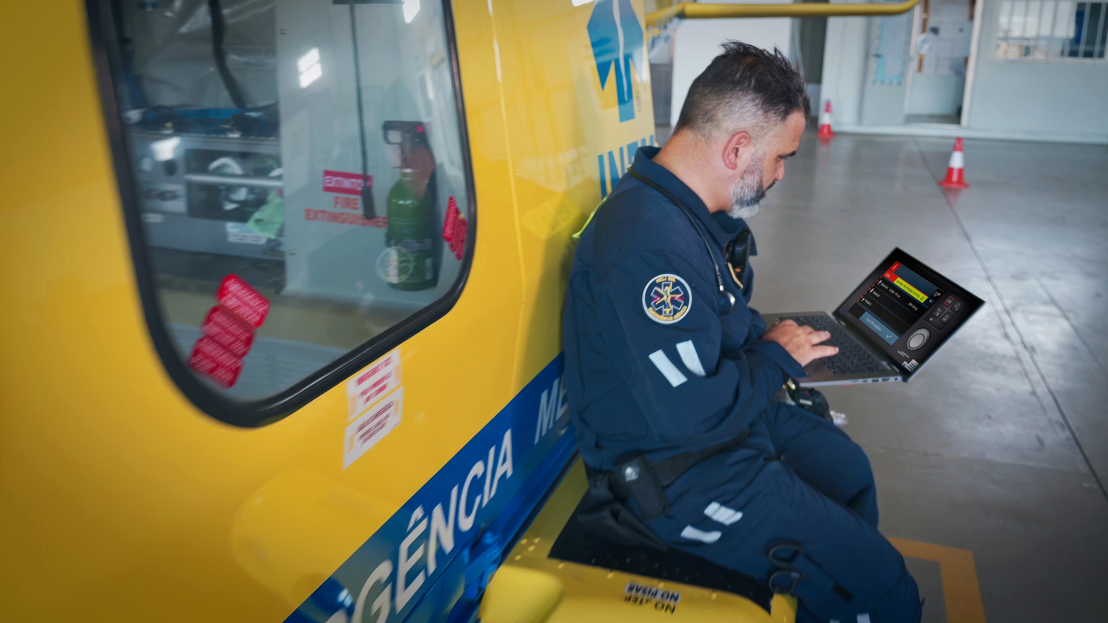 Paramedic sitting next to helicopter using VenTrainer on tablet